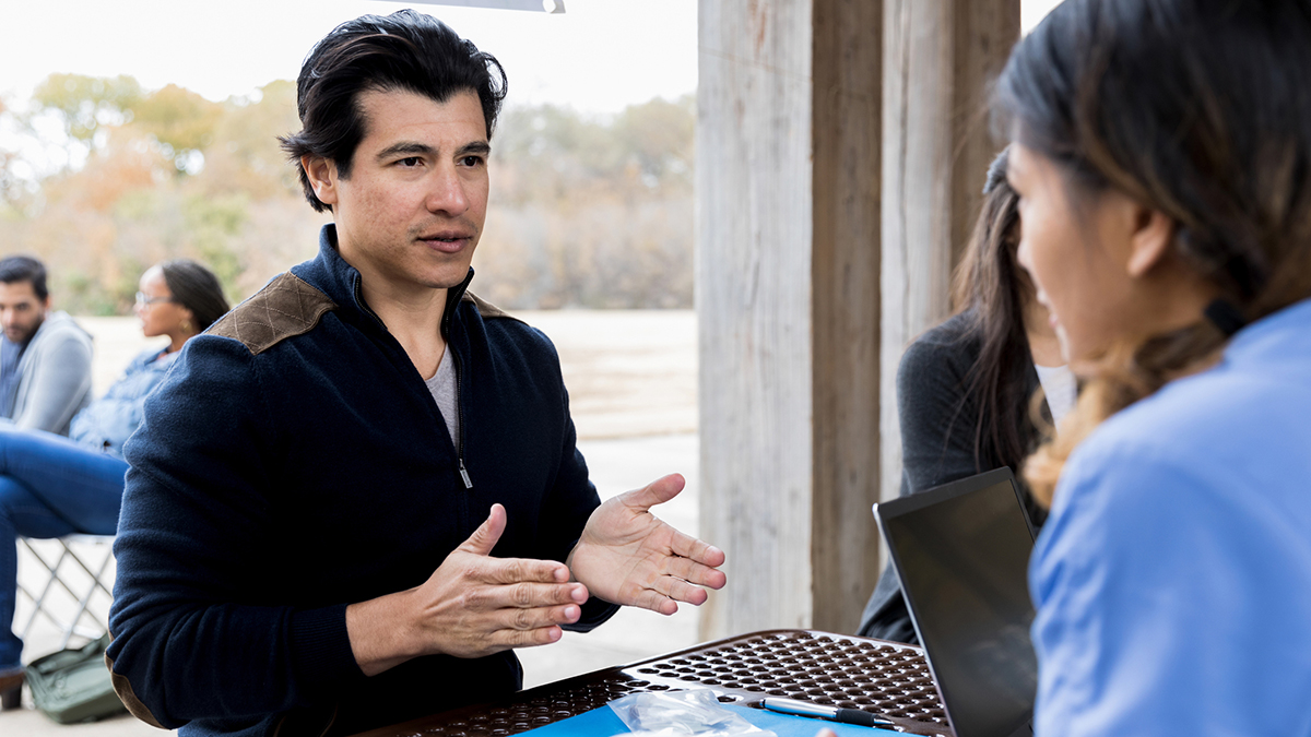 Hepatitis C Prevention and Control Thumbnail A man speaking with a healthcare professional outdoors
