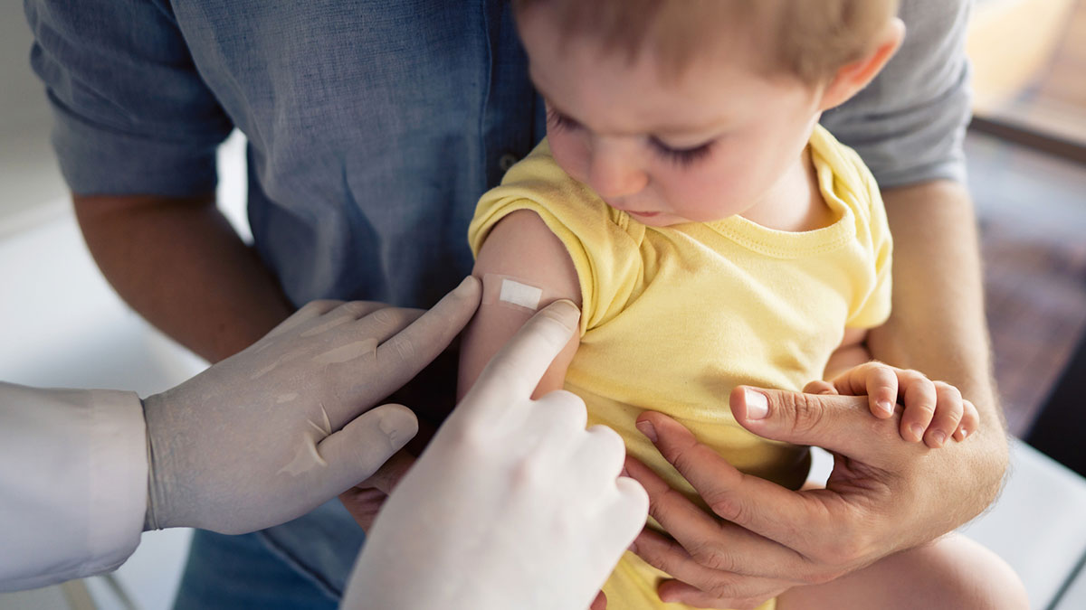 Provider administering vaccine to young child.