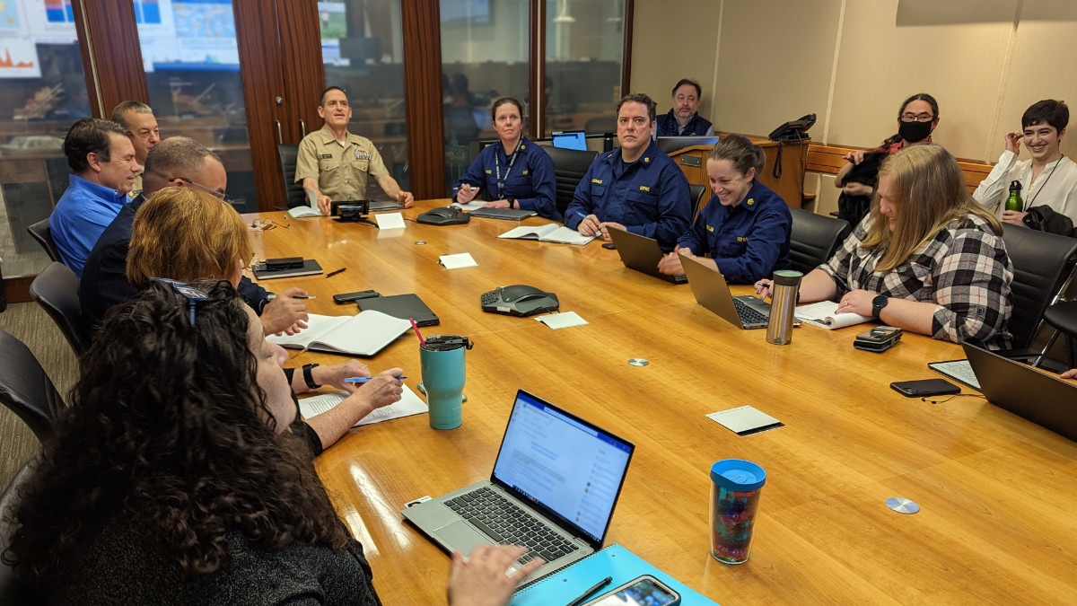 Dr. Jonathan Mermin sits at the head of a conference table surrounded by CDC officials.