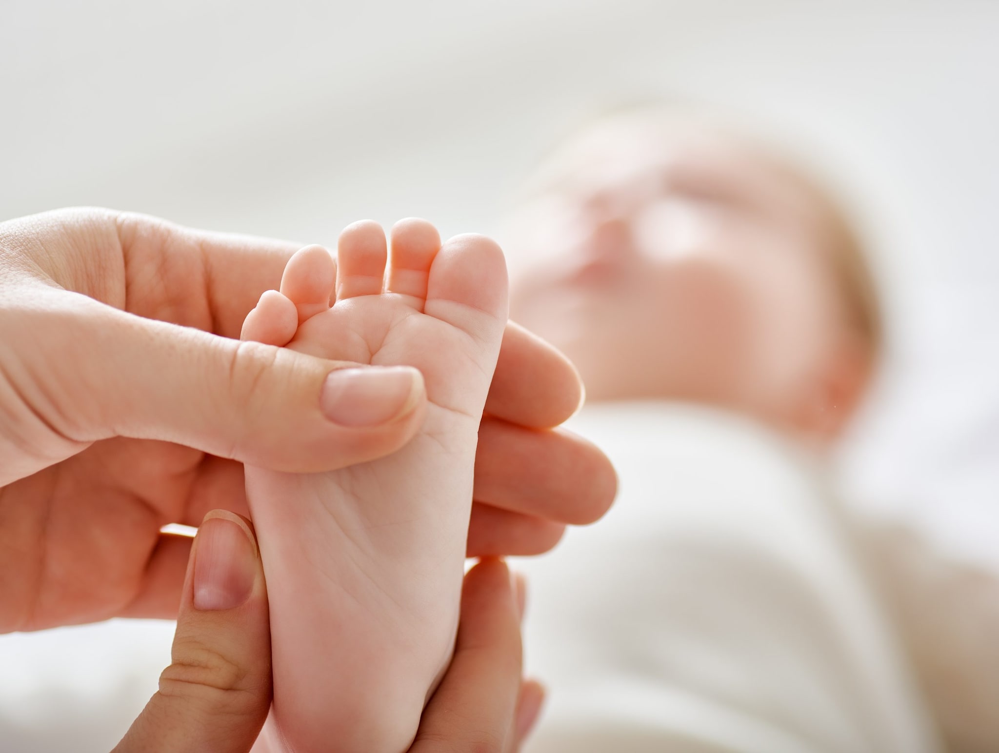 Image of a newborn's feet being held by mother.