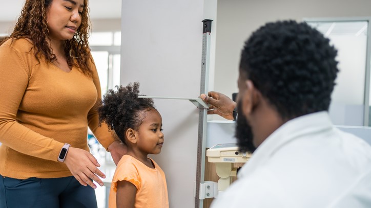 Doctor measuring young girl's height Doctor measuring young girl's height