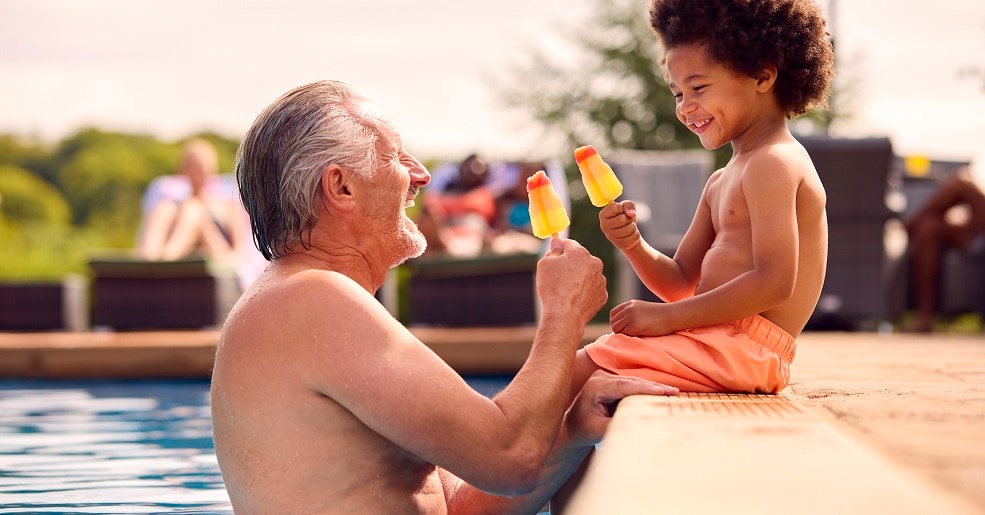 Grandfather with grandson in pool playing