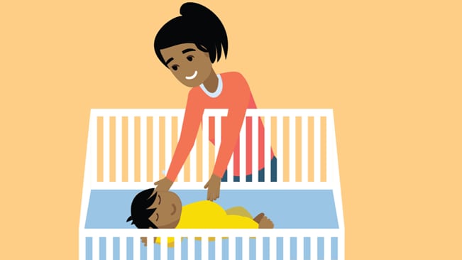 Mother laying baby to sleep on back in an empty crib