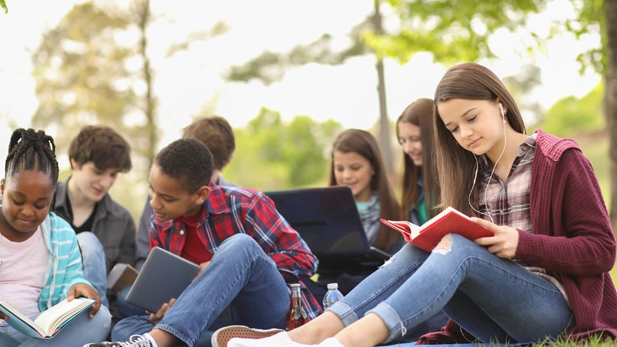 Diverse group of teens studying outdoors.